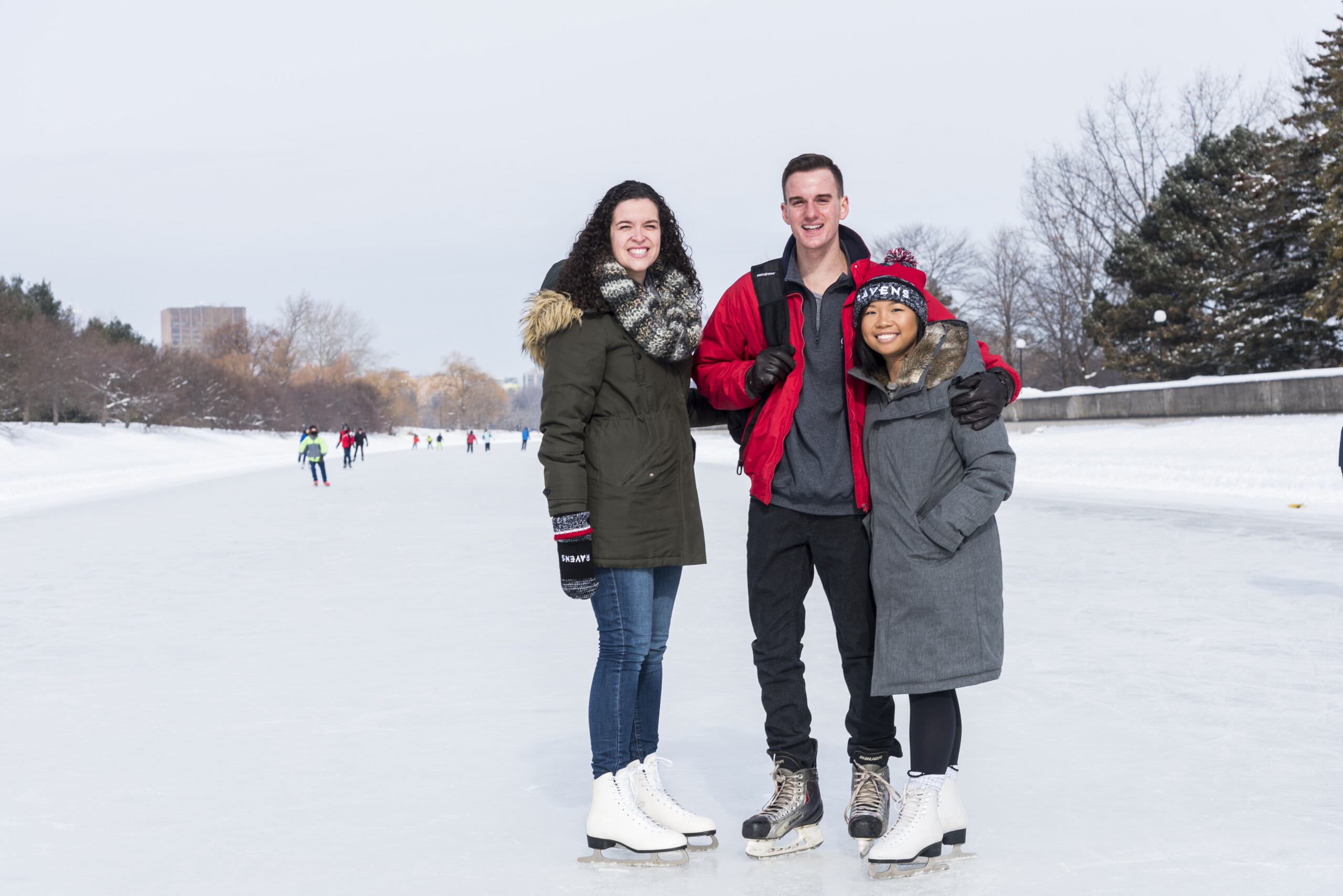Three students posing while ice skating on the Rideau Canal.