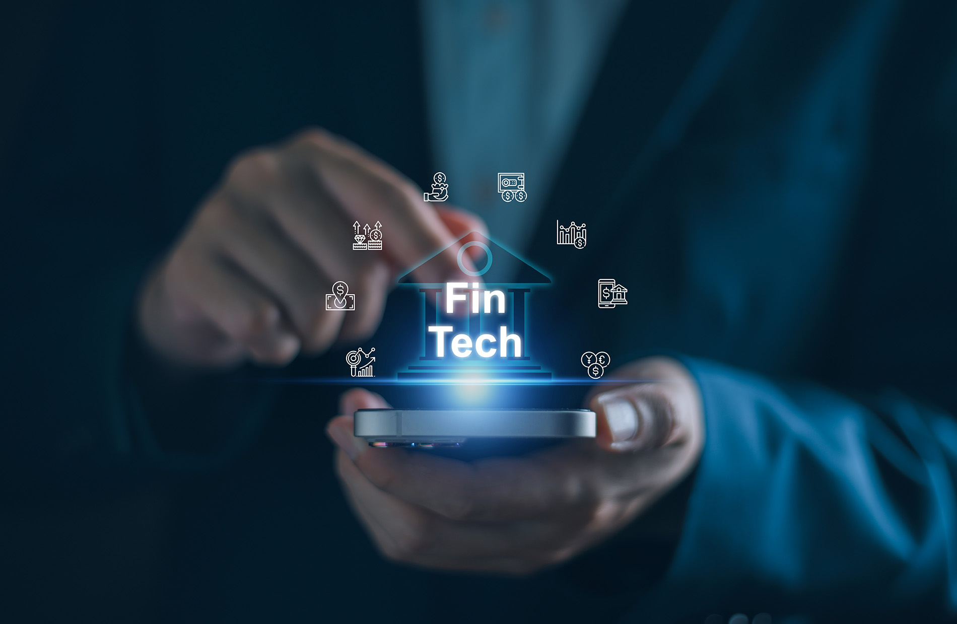 Business professional holding a phone that has illuminated financial and fintech icons radiating from the screen.